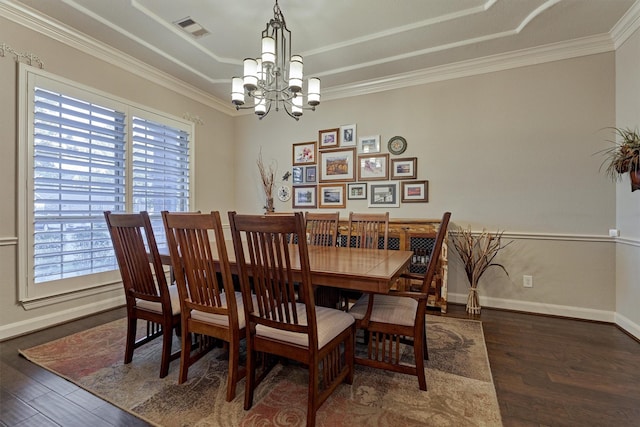 dining room with dark hardwood / wood-style flooring, a chandelier, and ornamental molding