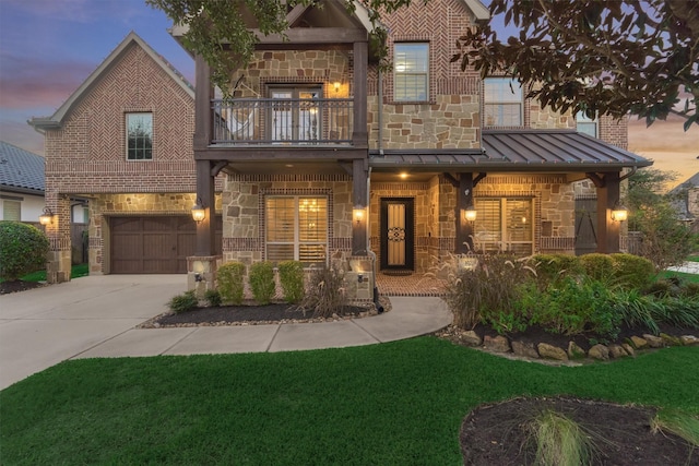 view of front of property with covered porch, a garage, a balcony, and a lawn