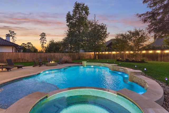 view of swimming pool featuring a pool with connected hot tub, a patio area, a lawn, and a fenced backyard