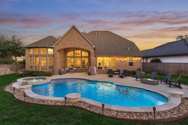 pool at dusk with an in ground hot tub, a patio, and an outdoor living space with a fire pit