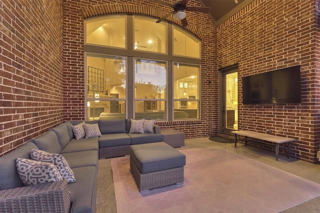 interior space with ceiling fan, brick wall, carpet floors, and high vaulted ceiling