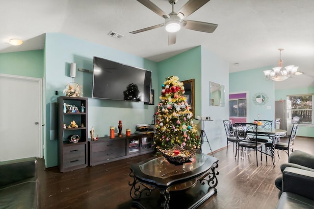 living room with vaulted ceiling, dark hardwood / wood-style flooring, and ceiling fan with notable chandelier