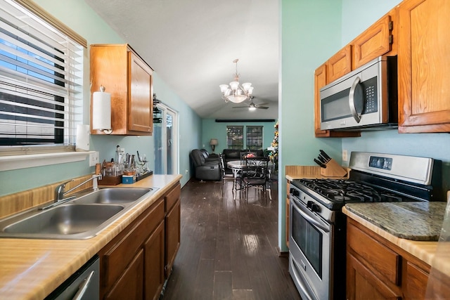 kitchen featuring dark hardwood / wood-style flooring, ceiling fan with notable chandelier, stainless steel appliances, sink, and lofted ceiling