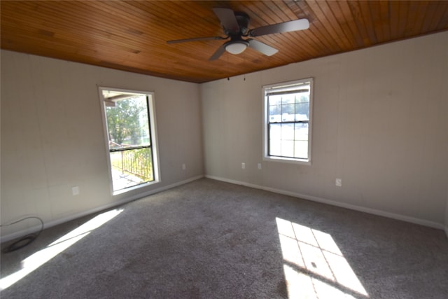 carpeted spare room featuring ceiling fan and wood ceiling