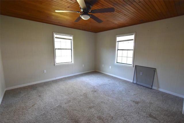 empty room featuring carpet, a healthy amount of sunlight, and wood ceiling