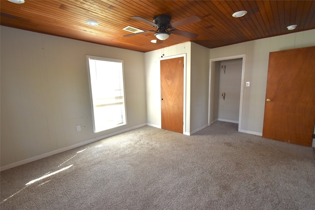 unfurnished bedroom featuring ceiling fan, wooden ceiling, and carpet floors