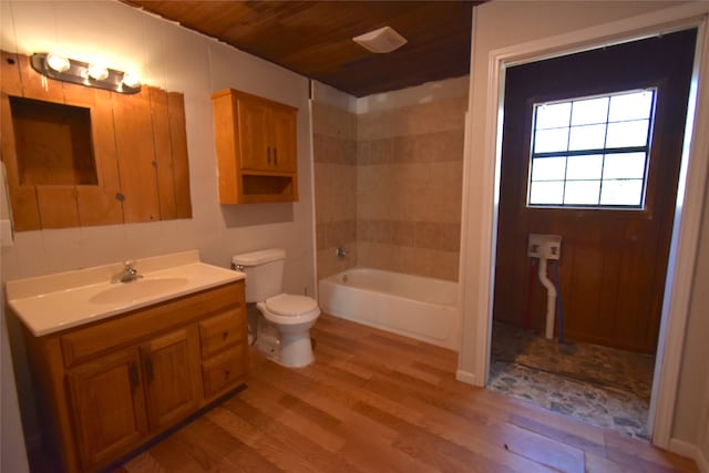 full bathroom featuring tiled shower / bath combo, hardwood / wood-style floors, toilet, vanity, and wood ceiling