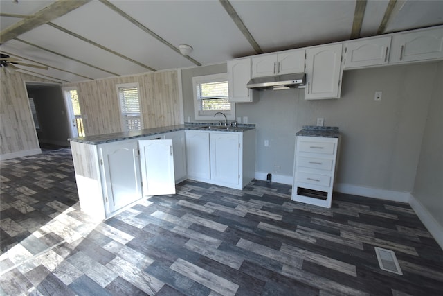 kitchen with beam ceiling, white cabinetry, ceiling fan, and sink