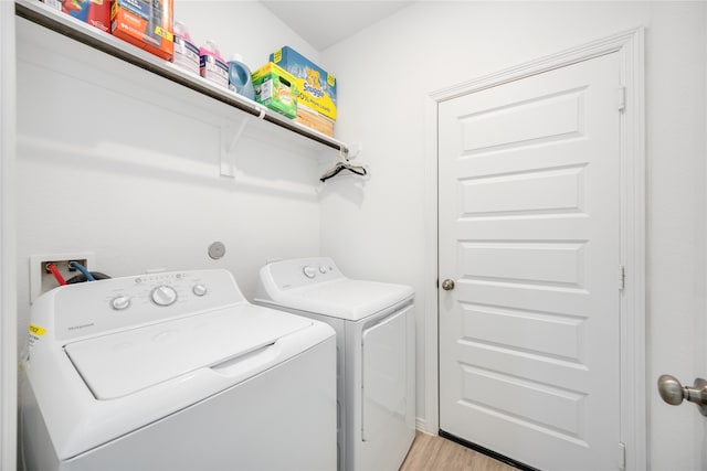 washroom featuring light hardwood / wood-style floors and washing machine and clothes dryer