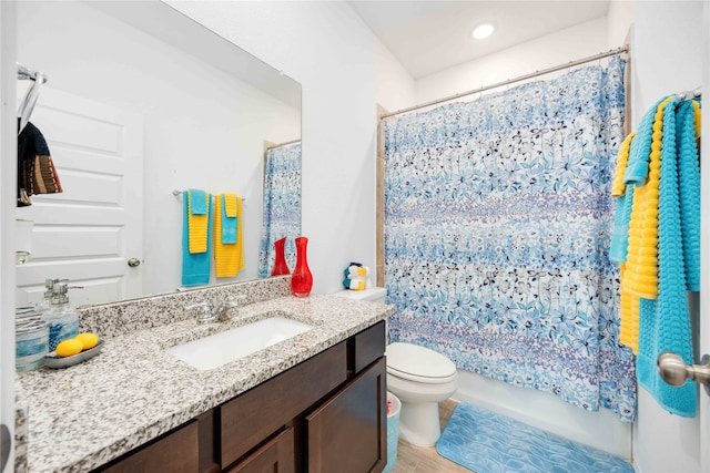 full bathroom featuring hardwood / wood-style floors, vanity, toilet, and shower / bath combo