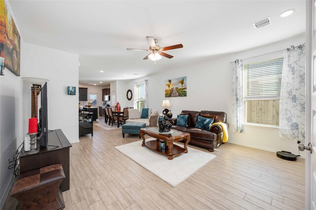 living room with light hardwood / wood-style floors and ceiling fan