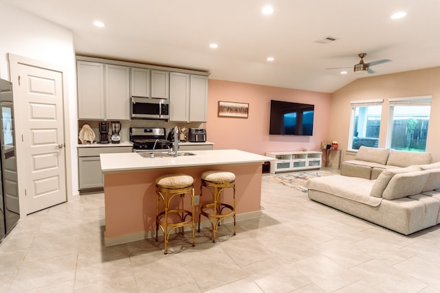 kitchen featuring a kitchen island with sink, sink, ceiling fan, and appliances with stainless steel finishes