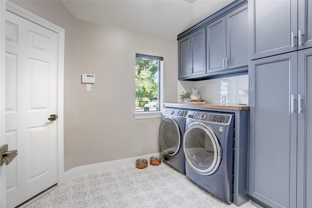 laundry room featuring light tile patterned flooring, cabinets, and independent washer and dryer