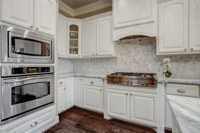 kitchen featuring white cabinets, light stone counters, stainless steel appliances, and dark wood-type flooring