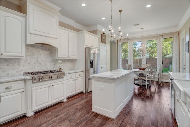 kitchen featuring white cabinets, appliances with stainless steel finishes, dark hardwood / wood-style flooring, and decorative light fixtures