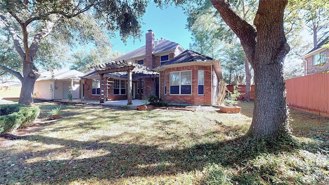 back of house featuring a lawn and a pergola