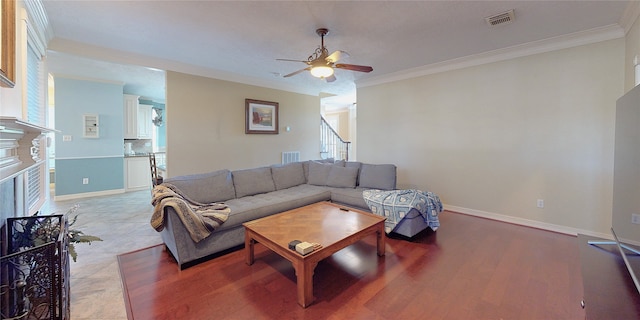 living room featuring a healthy amount of sunlight, ceiling fan, and ornamental molding