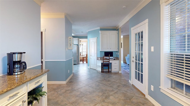 kitchen featuring light stone countertops, white cabinetry, and a healthy amount of sunlight