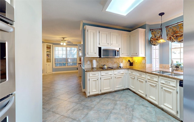 kitchen featuring hanging light fixtures, white cabinetry, sink, and stainless steel appliances