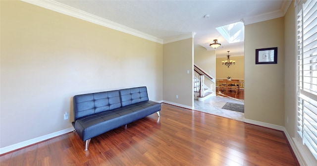 sitting room with a notable chandelier, a healthy amount of sunlight, wood-type flooring, and crown molding