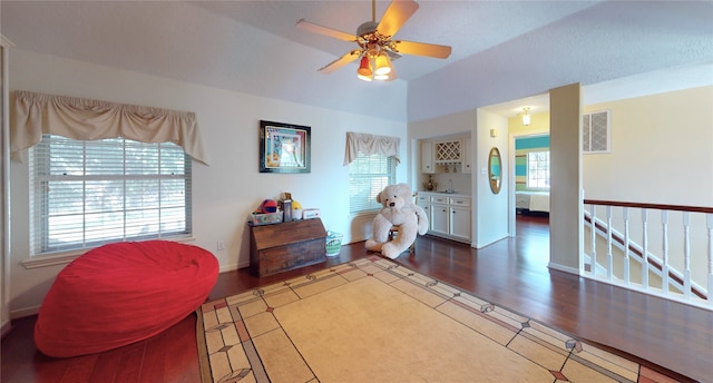 sitting room with ceiling fan and dark wood-type flooring