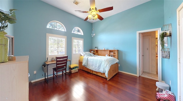 bedroom with dark hardwood / wood-style floors, ceiling fan, and high vaulted ceiling