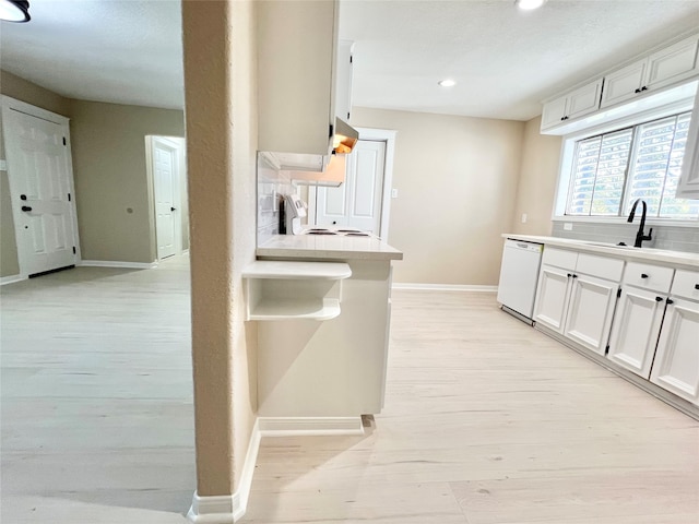 kitchen featuring light hardwood / wood-style flooring, white cabinets, white appliances, and sink