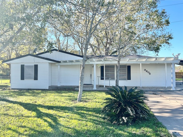 ranch-style home featuring covered porch and a front yard