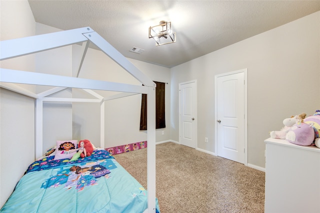 bedroom with carpet floors and a textured ceiling