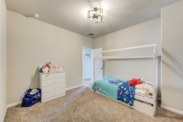 bedroom featuring carpet flooring and a textured ceiling