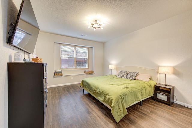 bedroom with a textured ceiling and hardwood / wood-style flooring