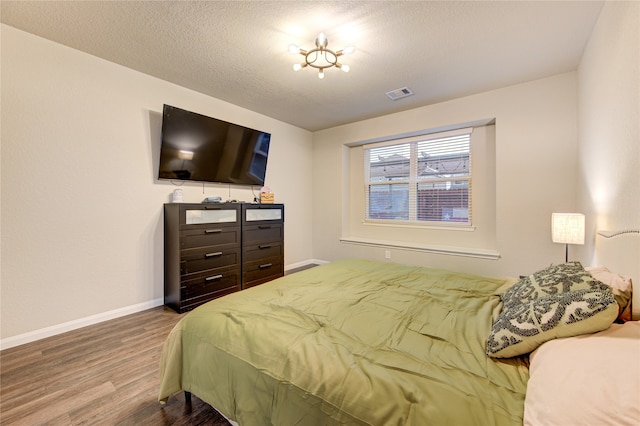 bedroom featuring hardwood / wood-style floors and a textured ceiling