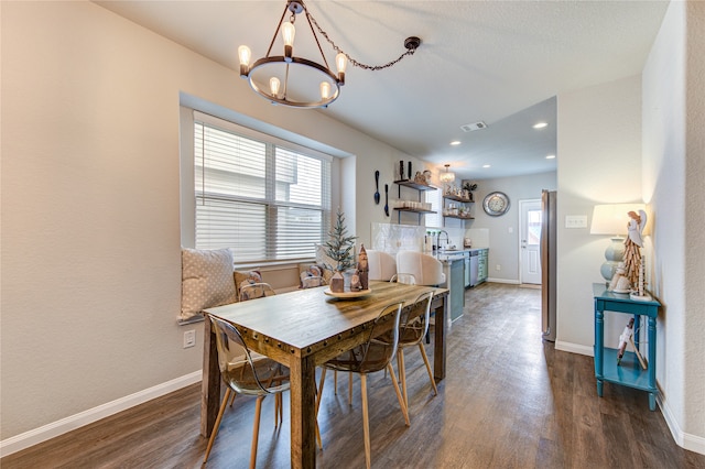 dining area featuring a notable chandelier, dark hardwood / wood-style flooring, and sink