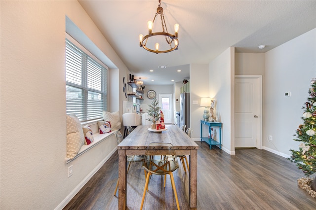 dining room featuring dark hardwood / wood-style flooring, a textured ceiling, and an inviting chandelier