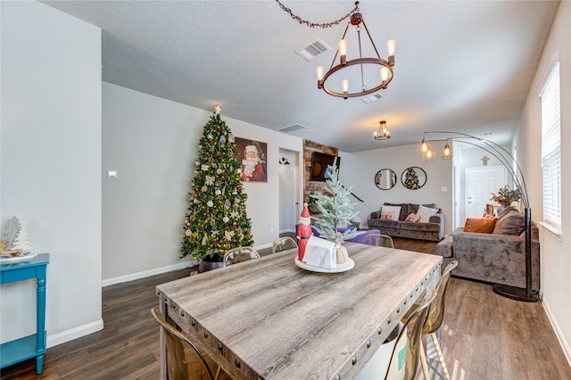 dining space featuring dark hardwood / wood-style flooring and an inviting chandelier