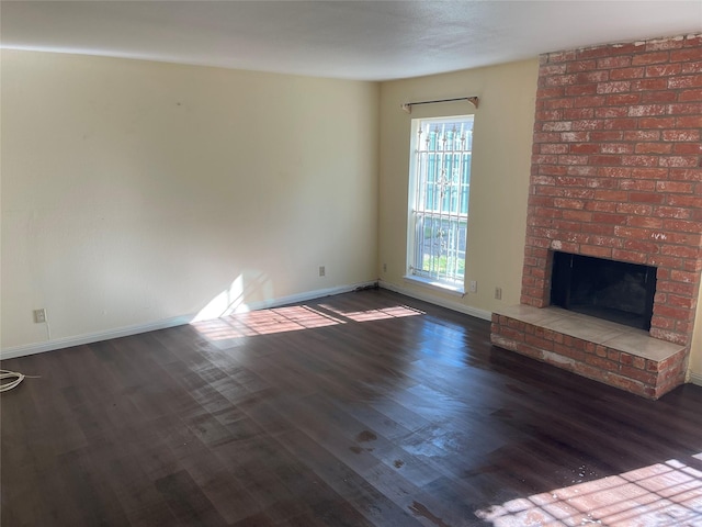 unfurnished living room with dark hardwood / wood-style floors and a fireplace