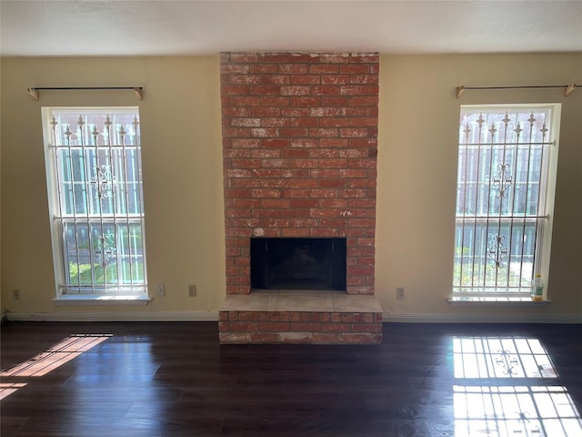 unfurnished living room with a wealth of natural light and dark hardwood / wood-style floors