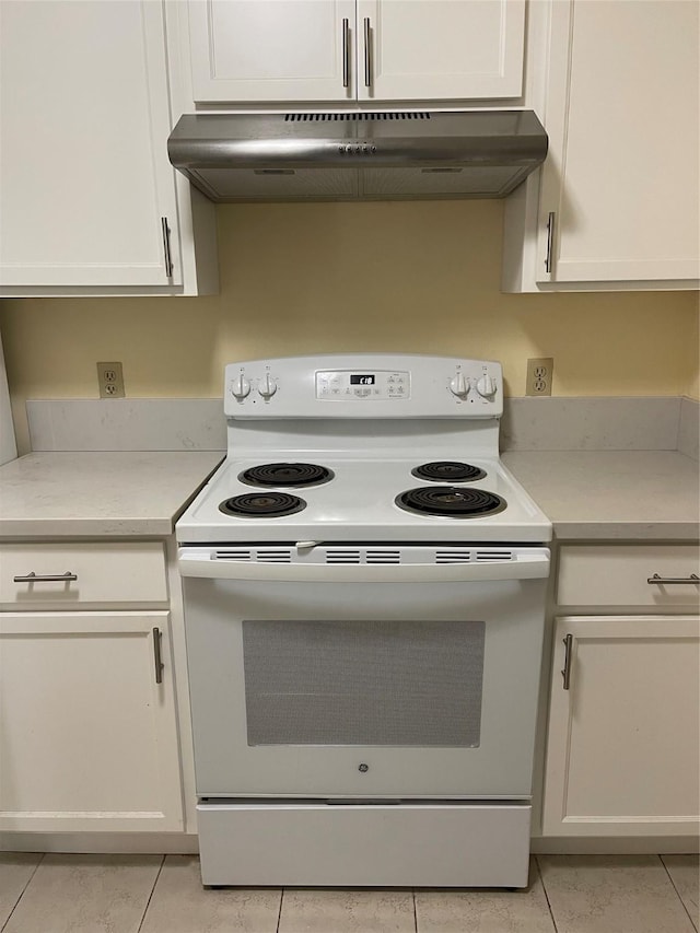 kitchen with ventilation hood, white electric range oven, white cabinetry, and light tile patterned floors