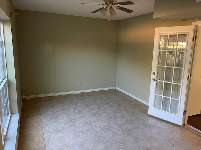 tiled empty room featuring ceiling fan