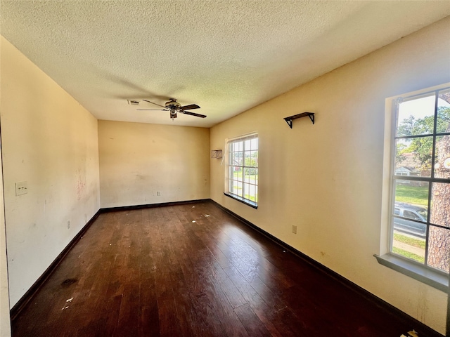 unfurnished room featuring ceiling fan, dark wood-type flooring, and a textured ceiling