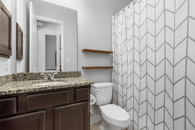 bathroom featuring a shower with shower curtain, vanity, and toilet