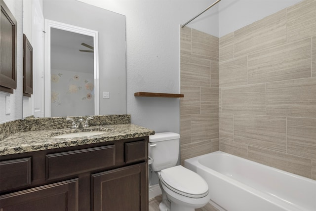 full bathroom featuring tiled shower / bath, ceiling fan, vanity, and toilet