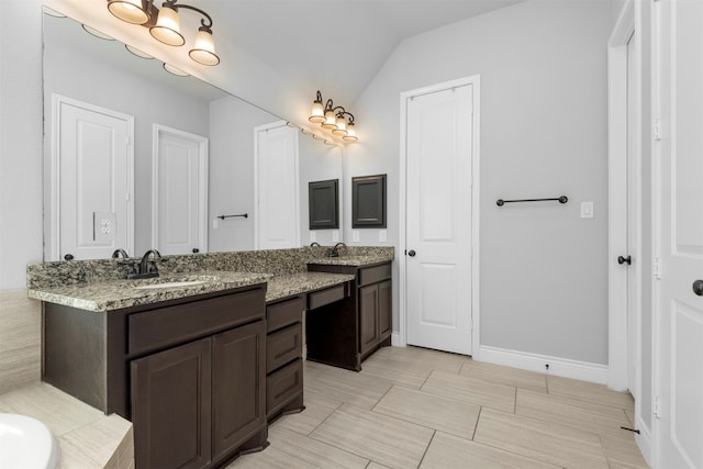 bathroom with vanity, vaulted ceiling, and a bathing tub