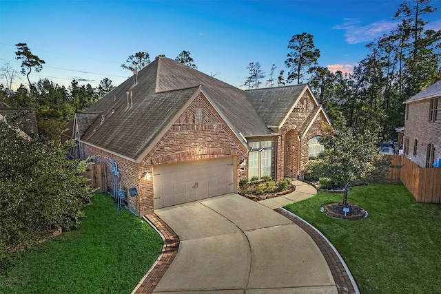 view of front of property with a garage and a yard