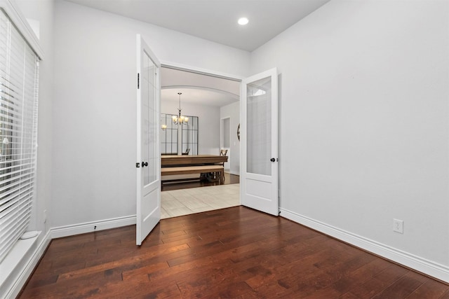 hall with a chandelier, french doors, and dark hardwood / wood-style flooring