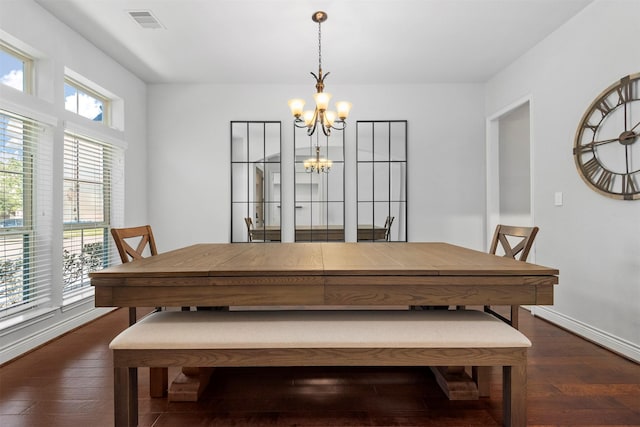 dining room featuring a notable chandelier, dark wood-type flooring, and a wealth of natural light