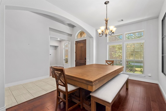 dining space featuring hardwood / wood-style flooring and a notable chandelier