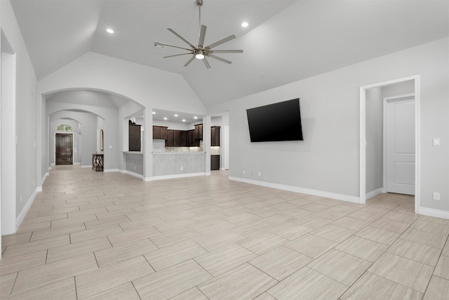 unfurnished living room with ceiling fan and high vaulted ceiling