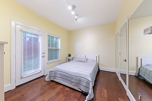 bedroom featuring access to exterior and dark wood-type flooring