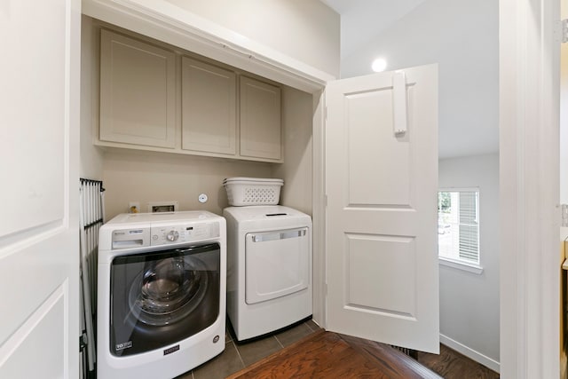 washroom with cabinets, separate washer and dryer, and dark tile patterned floors